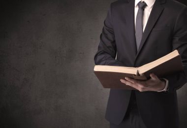 Elinde kitap tutan bir işadamı.