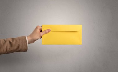 Zarf boş duvar arka plan ile tutan el