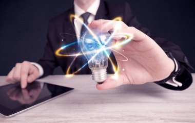 renkli bir ampul tutan işadamı