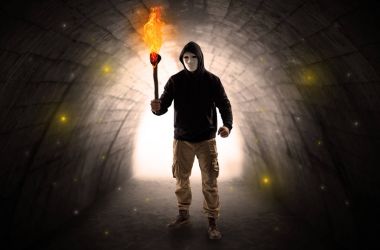 Karanlık bir tünelde flambeau yanma ile yürüyen adam