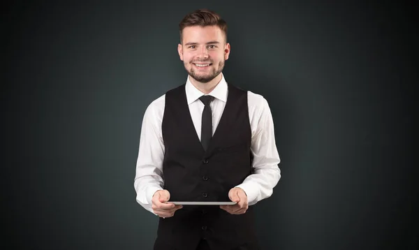 Empresário segurando tablet com fundo escuro — Fotografia de Stock