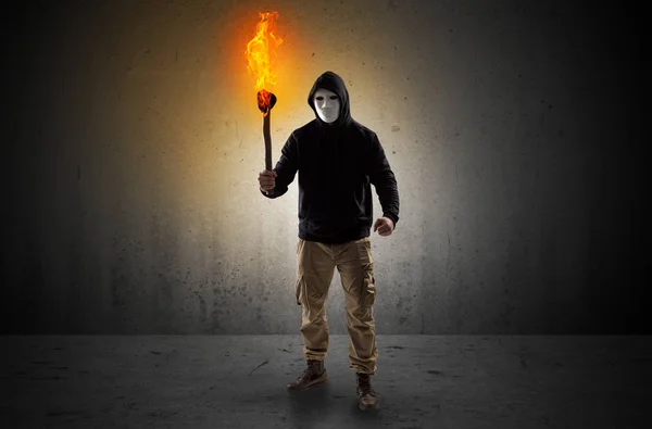 Man walking in an empty space with burning flambeau — Stock Photo, Image