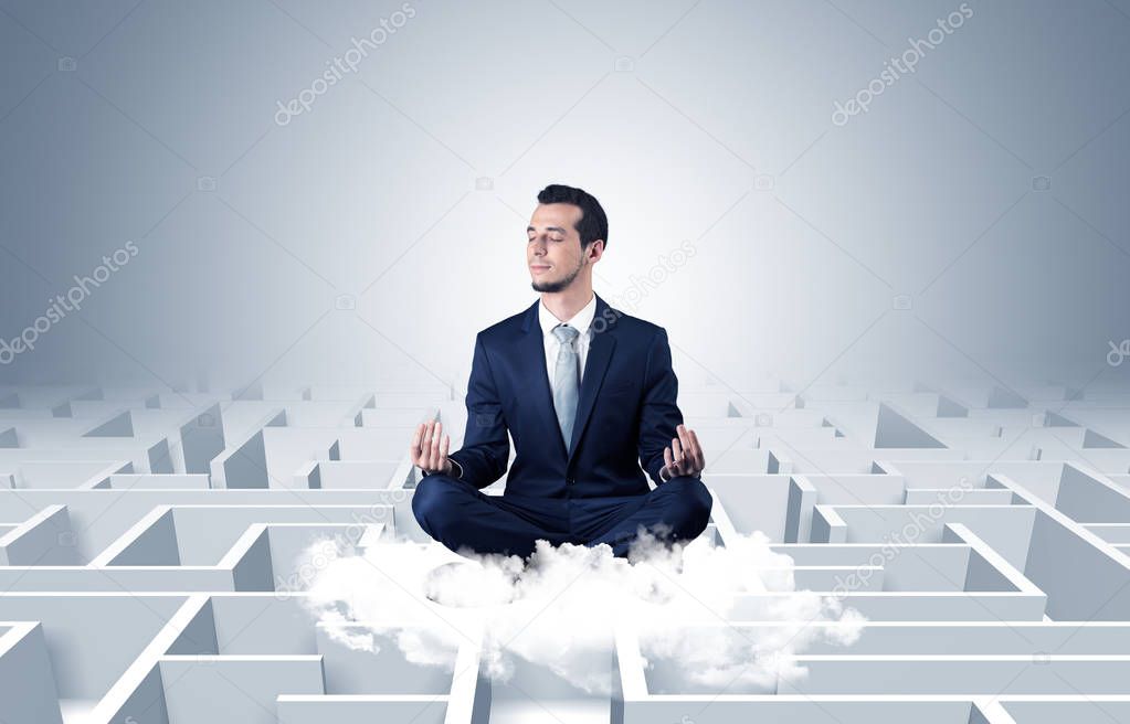 Businessman meditates on a cloud with maze concept