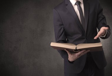 Elinde kitap tutan bir işadamı.