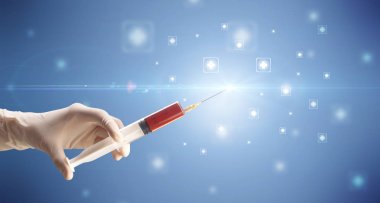 Kadın doktor elinde şırınga tutuyor.