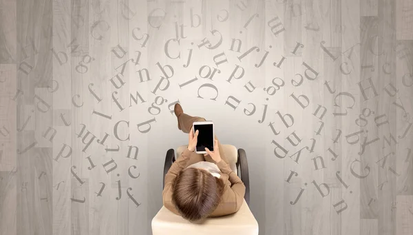 Letras com mulher usando laptop em uma cadeira — Fotografia de Stock