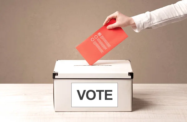 Nahaufnahme einer männlichen Hand, die ihre Stimme in eine Wahlurne wirft — Stockfoto
