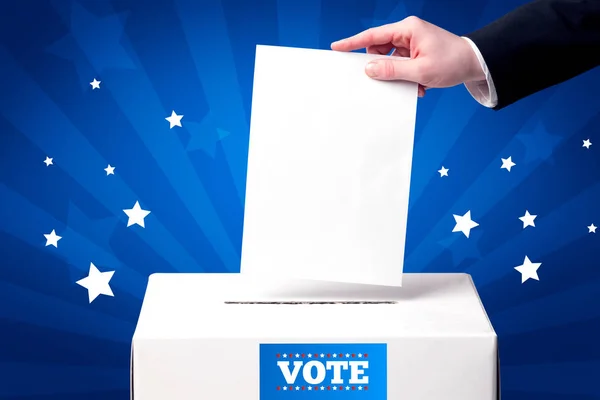 Рука с избирательным бюллетенем и деревянной коробкой — стоковое фото