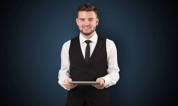 Empresario sosteniendo tableta con fondo oscuro — Foto de Stock