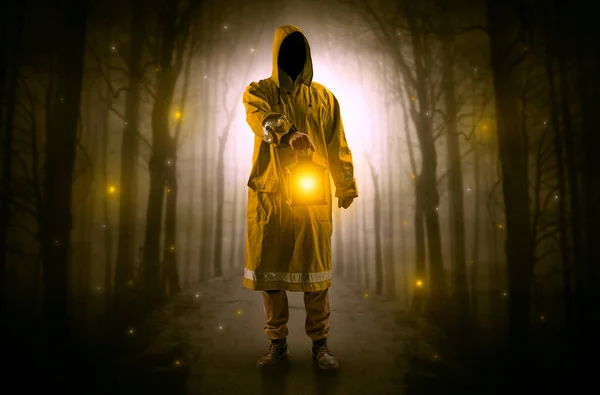 Mysterious man coming from a path in the forest with glowing lantern concept — Stock Photo, Image
