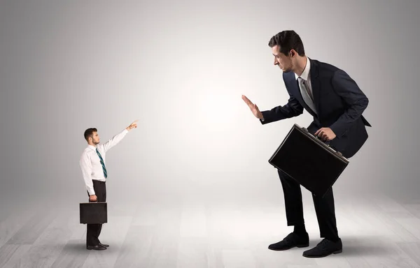 Small businessman pointing to a giant businessman — Stock Photo, Image
