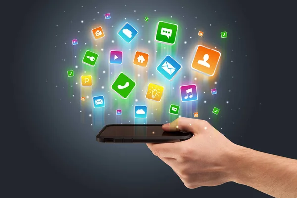 Main utilisant le téléphone avec des icônes d'application volant autour — Photo
