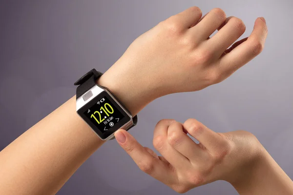 Kvinnlig hand bär och trycka på smartwatch — Stockfoto