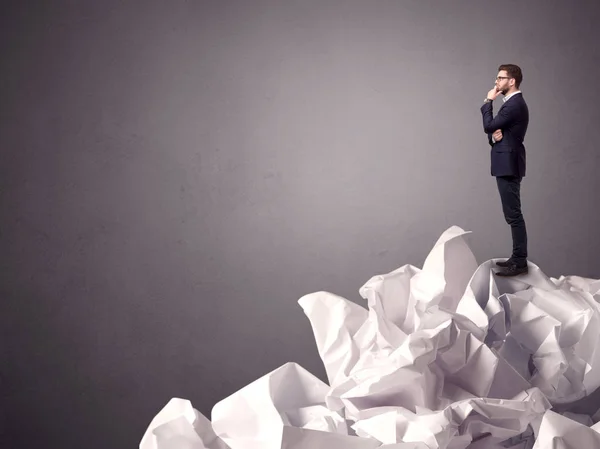 Businessman standing on crumpled paper — Stock Photo, Image