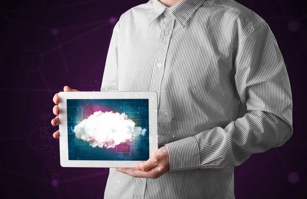 Businessman holding tablet with cloud graphic
