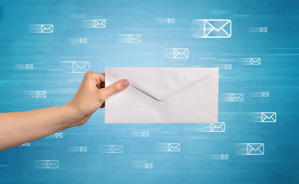 Рука держит конверт с символами сообщения вокруг
