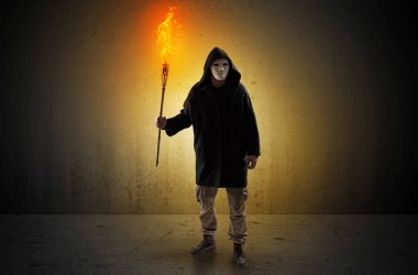 Boş bir alanda flambeau yanma ile yürüyen adam