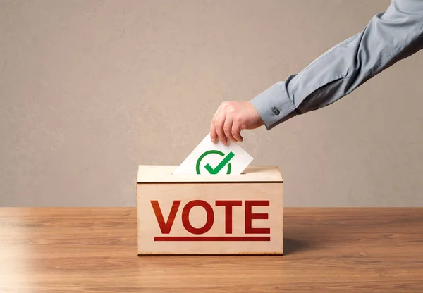 Close up of male hand putting vote into a ballot box — Stock Photo, Image