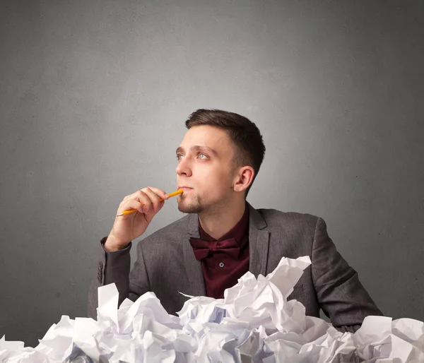 Businessman behind crumpled paper