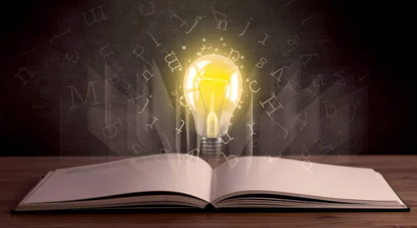 Lettere e lampadina su libro — Foto Stock