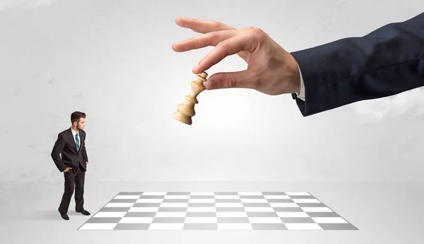 Kis üzletember sakkozni egy nagy kéz koncepció — Stock Fotó