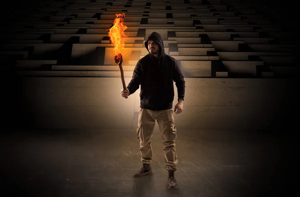 Man komt met branden flambeau uit het concept van het doolhof — Stockfoto