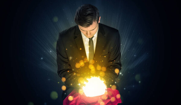 Businessman  sitting with sparkling magic ball