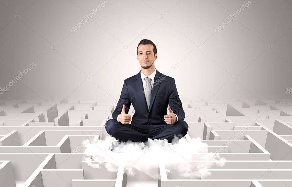 Businessman meditates on a cloud with maze concept