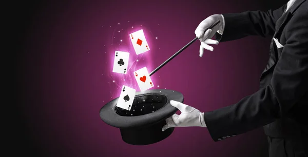 Magicien faisant tour avec baguette et cartes à jouer — Photo