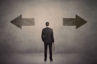 Duvarda iki grungy ok önünde duran bir karar alarak iş adamı 