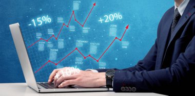 Satıcı dizüstü bilgisayarla grafikle çalışıyor.