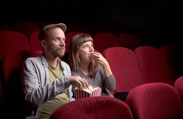 Junges Paar sitzt im roten Kino — Stockfoto