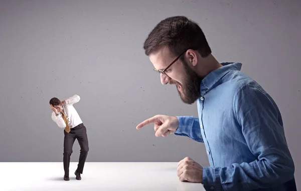 Joven hombre de negocios luchando con empresario en miniatura —  Fotos de Stock