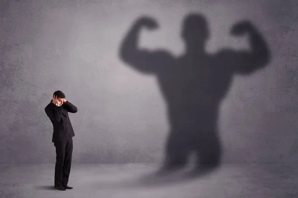 Uomo d'affari guardando il proprio concetto di ombra forte in forma — Foto Stock