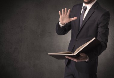 Elinde kitap tutan bir işadamı.