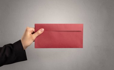 Zarf boş duvar arka plan ile tutan el