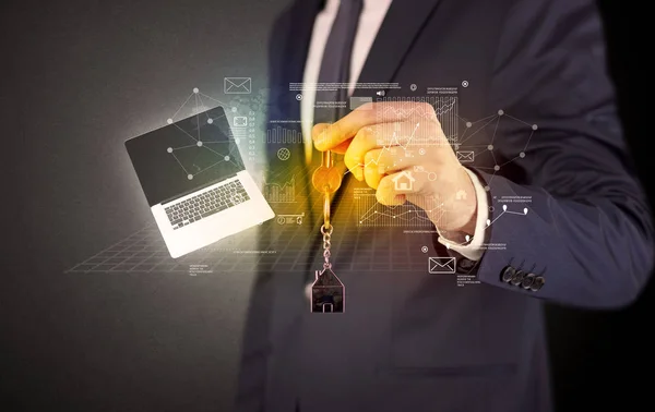 Businessman holding keys with graphs around — Stock Photo, Image