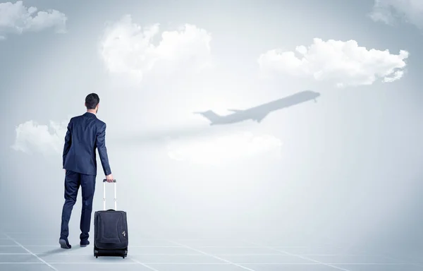 Affärsman med bagage look till ett flygplan — Stockfoto