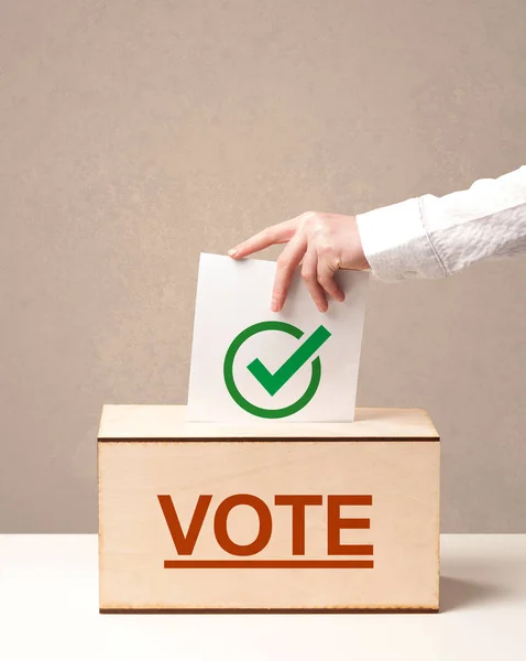 Крупный план мужской руки, помещающей голоса в урну для голосования — стоковое фото
