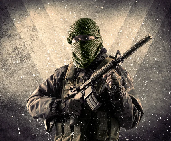 Ritratto di un pericoloso soldato armato mascherato con sfondo burbero — Foto Stock