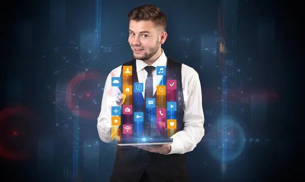 Man holding tablet with hologram app icons above