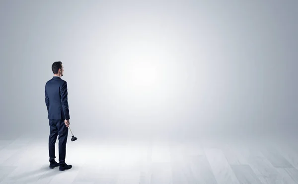 Hombre con objeto en la mano en un espacio vacío — Foto de Stock