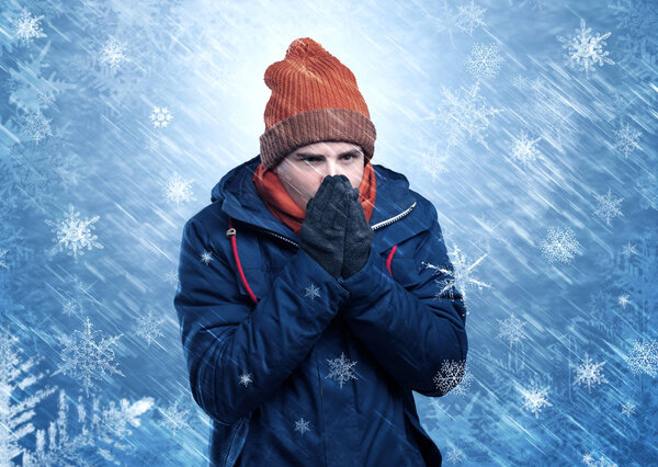 Boy freezing in warm clothing and snowing concept