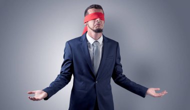 Kapalı göz işadamı bir duvarın önünde