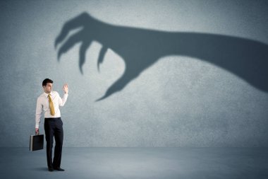 İş kişi büyük canavar pençe gölge kavramı korkuyor