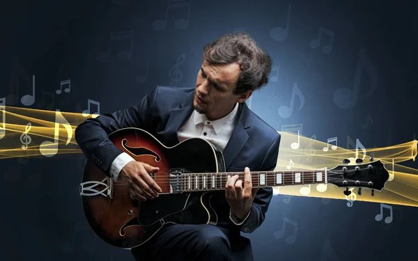 Músico tocando en la guitarra con notas alrededor — Foto de Stock