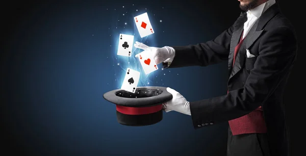 Trollkarl att göra trick med trollstav och spelkort — Stockfoto