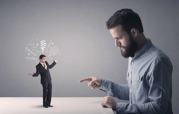 Young businessman fighting with miniature businessman — Stock Photo, Image