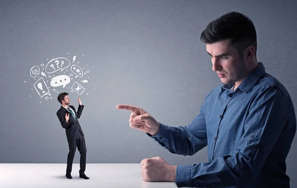 Young businessman fighting with miniature businessman — Stock Photo, Image