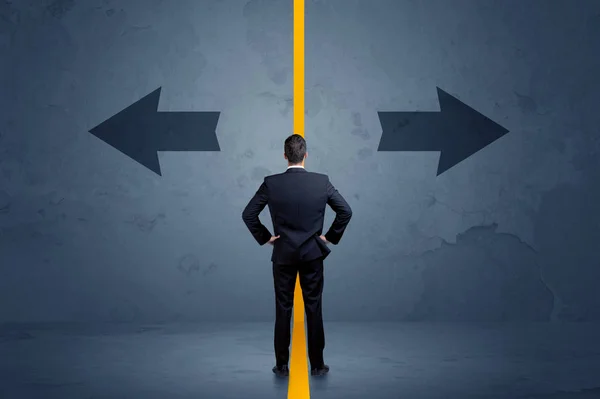 Business person choosing between two options separated by a yellow border arrow — Stock Photo, Image